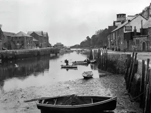 Drucke von Ein Blick entlang des Flusses vom Westende der Looe-Bridge. Das Julian's Möbelhaus ist auf der rechten Seite und es gibt mehrere Männer im Booten auf dem Wasser. Fotograf: S.C.Fox Looe Drucke: Der Fluss Looe in der Grafschaft Cornwall um die Jahrhundertwende