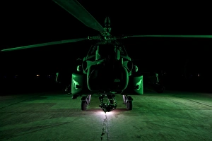Military Helicopter Drucke: An AH-64D Apache helicopter at night