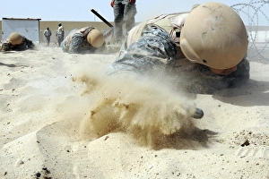 Military Training Exercise Drucke: Army soldier pulls himself through a sandpit on a Defender Challenge course