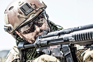 Special Forces Soldier Drucke: Close-up of a commando fighter shooting a submachine gun