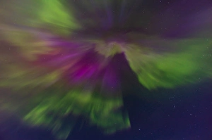 Atmospheric Mood Photos Drucke: The converging rays of an aurora borealis overhead