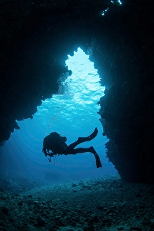 Diver In Pacific Ocean Drucke: A diver exiting a swim through cavern