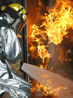 Emergency Services Photography Drucke: Firefighter extinguishes a simulated structural fire