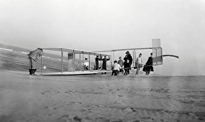 Early Aircraft Design Drucke: Orville Wright and his team preparing the Wright brother's glider for flight
