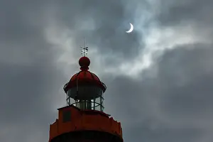 Brittany Coast Scenery Drucke: Solar eclipse in a cloudy sky above the lighthouse at Pointe Saint-Mathieu