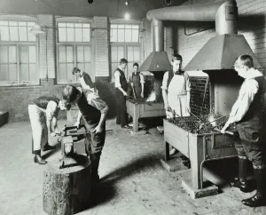 Jungen arbeiten im Schmiedewerkstatt mit Ofen bei der Beaufoy Institute in London 1911