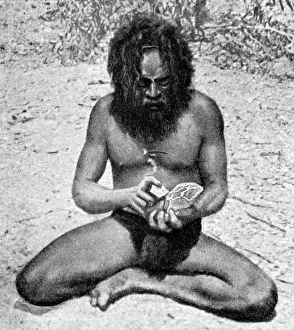 Drucke von Ein Mann aus der Warramunga-tribe macht ein Steinbeilschneid mit einem Block diorit durch einen kleinen Klumpen harten Quarzits Bilder Datiert 2007 November: Ein Mann aus der Warramungatribu macht einen Steinaxthammerkopf in Australien im Jahr 1922