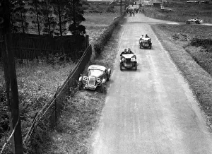 Brooklands Racing Circuit Drucke: Two MG M types passing a broken down 1928 Alta Prototype