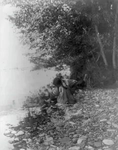 Indigenous People USA Drucke: By the river-Flathead, c1910. Creator: Edward Sheriff Curtis