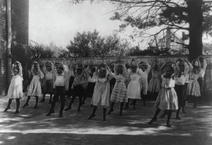 Physical Education History Drucke: School children learning a dance in a school yard