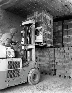 Michael Walters Photography UK Drucke: A yardsman stacking pallets of bricks