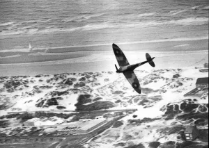 Ein Spitzbomber der Royal Air Force fliegt über die Sanddünen von Dünkirchen