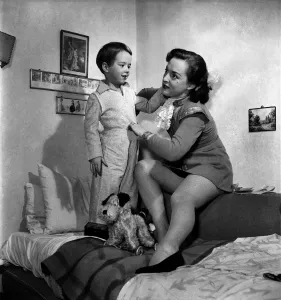 00019 Drucke: Mutter sorgt sich um ihren Sohn und stellt ihn hier zu Bett. Dezember 1952 C6310-001