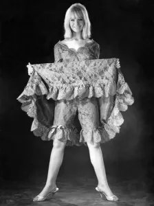 Eine Frau zeigt ihre Unterwäsche unter ihrem Kleid auf, Dezember 1964