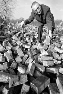 00039 Drucke: Alter Mann sucht durch eine Haufel von Backsteinen, Dezember 1969 Z11973-001
