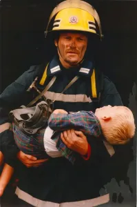 00072 Drucke: Ein Feuerwehrmann rettete einen jungen Jungen aus einem Brand am 01
