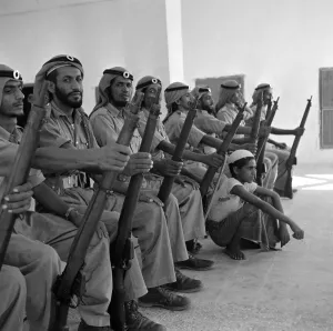 00086 Drucke: Mitglieder der Verteidigungskräfte von Abu-Dhabi posieren vor dem Kameras mit einem jungen Jungen