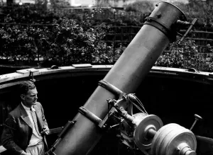 Schauspieler Will Hay ist hier mit seinem 4,5 Meter langen Teleskop im Hinterhof zu sehen