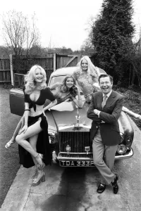 Reg Varney, Schauspieler, stellt sich mit drei Modellen - Lia Flanagan und Vee Brooks