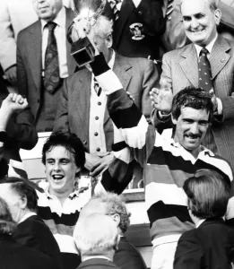 Drucke von Wales Rugby-Union-Finale - Pontypool 18:6 Swansea. Der Kapitän von Pontpool Jeff Squire hält den WRU-Cup mit dem Mann des Spiels David Bishop (links) am 30. April 1983 0600bis0699 Drucke: Wales Rugby-Union-Finale in Pontypool, 18 : 06 gegen Swansea von Jeff Squire