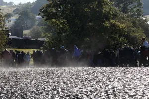 Zuschauer gehen durch Schlamm