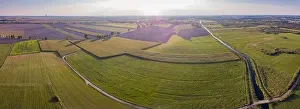 Luftaufnahme: Felder und Windräder im Sonnenunterganglicht. Drohnenpanorama