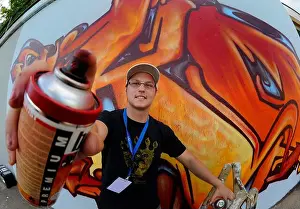 Drucke von Künstler Tarik Yilmaz Tiko sprüht ein Graffiti auf eine der größten legalen Graffitifassaden in Saarbrücken, Deutschland, am 25. August 2012 Straßenkunst Graffiti Drucke: Künstler Tarik Yilmaz Tiko sprüht ein Graffito auf einer der größten legalen Graffiti-Wände in Saarbrücken