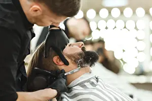 Friseur schneidet Bartform für Mann.