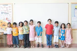Kinder stehen vor dem Weißbrett im Klassenzimmer