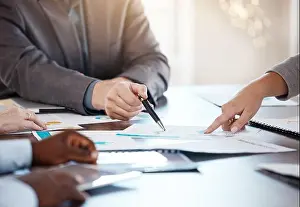 Unternehmenskonferenz, Dokumente und Hände in einer Unterhaltung über Geschäftsanalyse-Datenbericht im Büro.