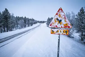 Befahrungsverbotsschild mit Schnee bedeckt auf einer leeren, schneereichen Straße im Land der Lappen