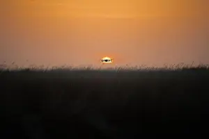 Rakete Quadkopter mit digitalem Kamerasystem im Flug bei Sonnenuntergang, Schatten der Rakete beim Sonnenuntergang