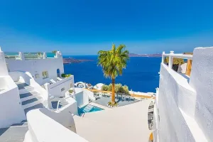 Schöne Terrasse von Santorin mit weißen Architekturen und sonniger Blick auf die Kalkulation. Bekanntes Touristenhotelresort für Reise-Urlaubsort