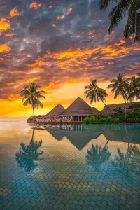 Faszinierendes Poolufer mit Sonnenuntergangs-Himmel und Palmenreflexion. Luxuriöse tropische Strandlandschaft mit unendlichem Schwimmbad. Erstaunliches Reisehintergrundbild in vertikaler Perspektive
