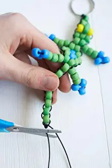 Ein Beutelkriecher-Schnurzubehör herstellen, überschüssige Schnur mit Scheren abschneiden.