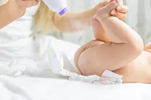 Die Mutter wechselt das Baby-Unterwäsche aus, Fokussierung auf die Person, Menschen