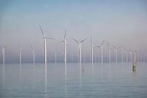 Windpark mit Offshoren und Wolken im blauen Himmel, Windpark über dem Meer aus der Drohne mit Turbinen