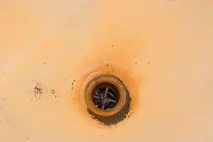 Altes schmutziges Bad mit Rost und einem Loch für die Entwässerung unreiner Wasser in Abwasserrohre.