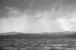 Strahlen durch Wolken über das Wasser