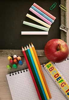 Schulgegenstände für Schüler. Tafel, Stifte, Bleistifte und Apfel.