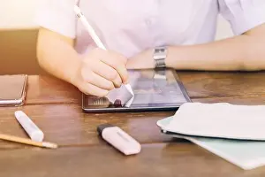 Schüler nutzt Touchscreen-Tablett-Computergerät zur Lernarbeit und Schreibübungen, moderne Technologie für die Bildung