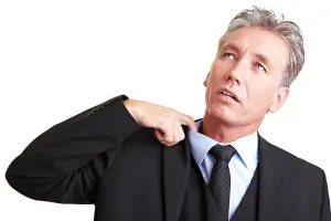 Schwitender Manager zieht sein Hemd mit seinem Finger.