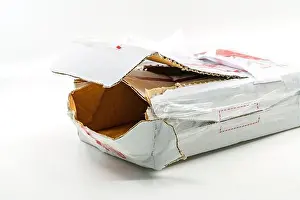 Ein zerrissener weißer Sendungsbox auf weißem Hintergrund. Nahansicht eines großen Lochs auf der Sendungsbox. Die gestohlene innere Paketbox.