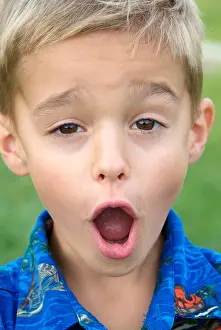 Ein achtjähriger Junge macht Gesichter vor die Kamera.