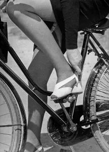 Eine Frau in einem Straßenanzug, die auf einer Fahrradstraße sitzt.