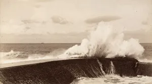 Coastal Scenery Drucke: A high wave breaks against a breakwater