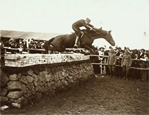 Jockey On Horseback Drucke: A man rides over an obstacle