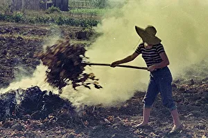 Eine Bauernfrau, die Unkraut verbrennt