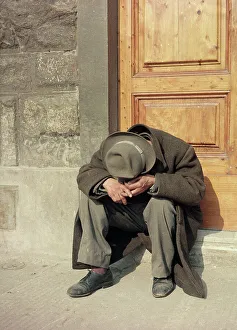 Ein Bettler sitzt auf einer Schwelle in Florenz