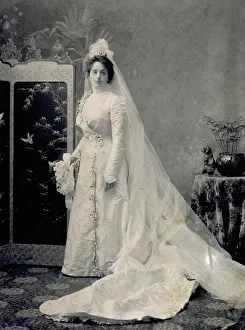 Porträt einer jungen Frau im Brautkleid mit langem Schleier und Blumen